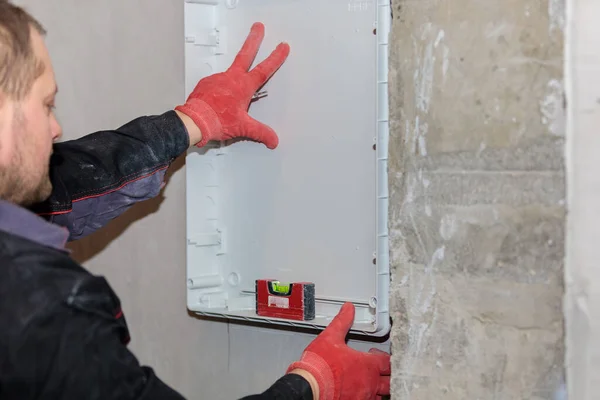 Elektrikçi dener ve elektrik panelinin çizgilerini işaretler..