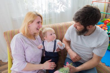 Dad with children congratulate mom on the holiday, mother's day. Have fun, laugh and give flowers