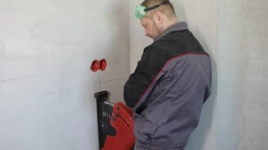 Elektrikçi tel kanalı dairesel testere ile kesiyor..