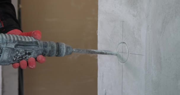 전기 기술자가 전동 공구를 사용하여 벽에 구멍들을 뚫는다. — 비디오