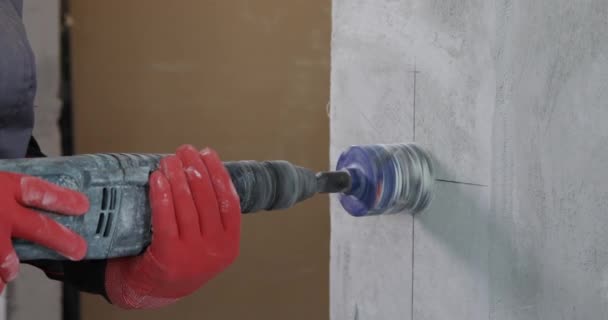 An electrician drills holes for sockets with a diamond core bit — Stock Video