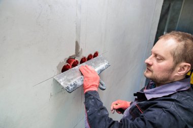 Elektrikçi prizler ve kablolar için delikler ve kanallar alçılayacak.