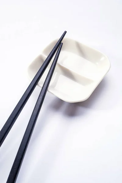 Black wooden sushi sticks with sauce saucer. View from above — Stock Photo, Image