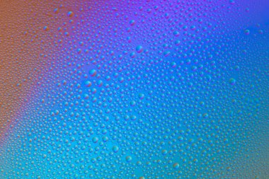 Camdaki damlalardan renkli ve soyut bir arkaplan. Gökkuşağı renk geçişleri.