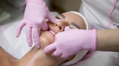 Kuaför kızın yüzüne yüz masajı yapıyor..