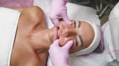 Kuaför kızın yüzüne yüz masajı yapıyor..