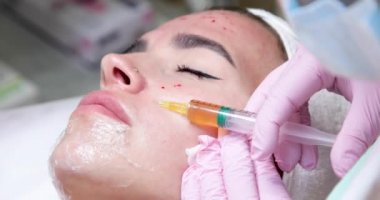 Doktor genç bir kızın yüzüne kan plazması enjekte ediyor..