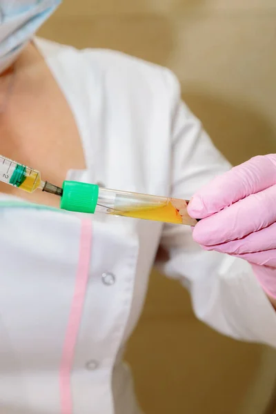 The specialist draws out the blood plasma from the test tube using a syringe. — Stock Photo, Image