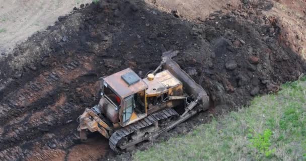 Traktor mengumpulkan bumi dalam tumpukan besar dengan ember. — Stok Video