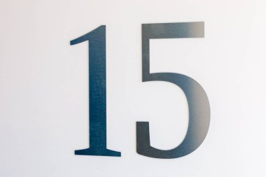 Duvarda 15 numara, hafif metalden oyulmuş. Yer tanımlaması