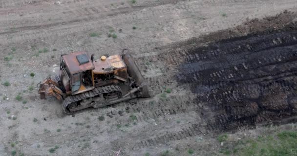 Traktor mengumpulkan bumi dalam tumpukan besar dengan ember. — Stok Video