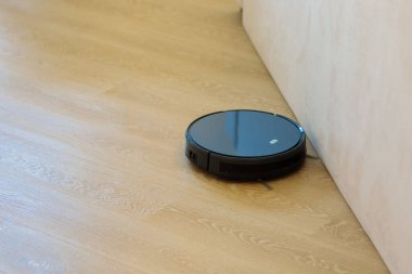 Dairesel robot süpürge oturma odasındaki döküntüleri topluyor..