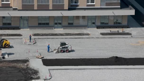 Trabajadores de equipos especiales nivelan piedra triturada para pavimentación de asfalto — Vídeo de stock