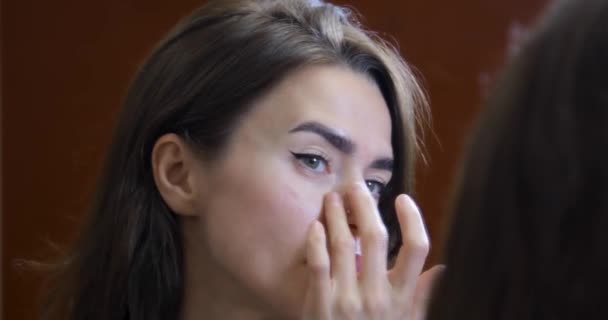 Ein junges Mädchen blickt nach einer Massage in den Spiegel. — Stockvideo