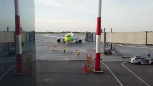 O avião no aeroporto puxa um trator para o local de segurança antes da partida. — Vídeo de Stock