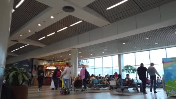 Przed odlotem na lotnisku jest gwara ludzi, w poczekalni. — Wideo stockowe