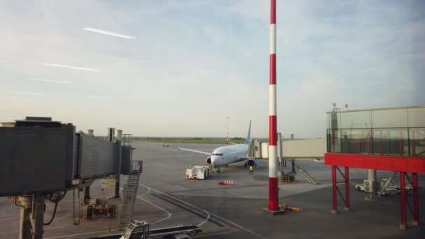 O avião no aeroporto puxa um trator para o local de segurança antes da partida. — Vídeo de Stock