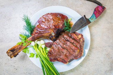 Beyaz tabakta baharatlı kızarmış et. Akşam yemeği için fırında et ve bir bardak kırmızı şarap..