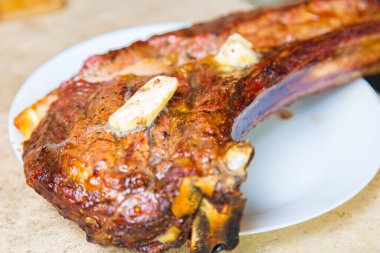 Beyaz tabakta baharatlı kızarmış et. Akşam yemeği için fırında et ve bir bardak kırmızı şarap..