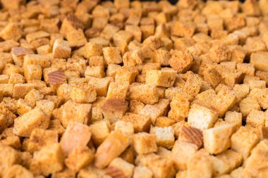 Kare şeklinde ekmek kırıntıları. Fırında kızartılmış altın kahverengi ekmek kırıntıları..