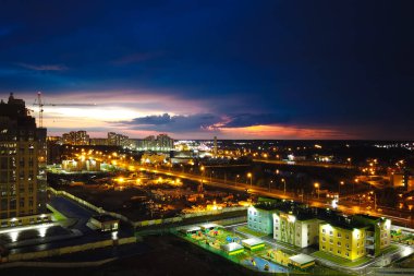Gece şehrinin ışıklarının en üst görüntüsü. Batan güneş, alacakaranlık. Hareket halindeki arabalardan ışık izleri..