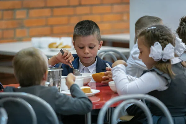 Birinci sınıflar okul kafeteryasında yemek yerler. 1 Eylül 'de yemek odasında öğle yemeği. Moskova, Rusya, 2 Eylül 2019