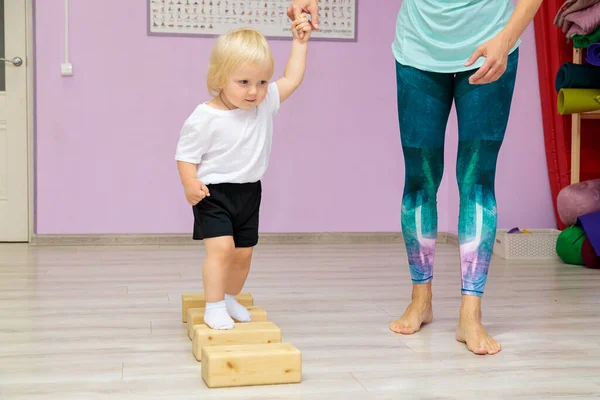 Anne ve bebek spor salonunda gelişim egzersizleri yapıyorlar..