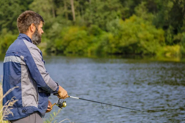 髭を生やした男が川で釣りをしている。. — ストック写真