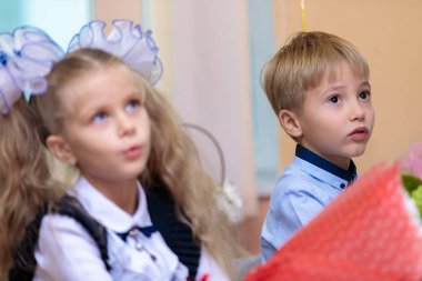 1 Eylül 'de çocuklar sınıfta masalarında otururlar. Birinci sınıflar ilk derste öğretmeni dikkatle dinlerler. Moskova, Rusya, Eylül 2021
