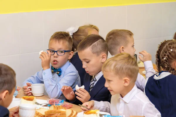 Birinci sınıflar okul kafeteryasında yemek yerler. 1 Eylül 'de kafeteryada öğle yemeği. Moskova, Rusya, 1 Eylül 2021