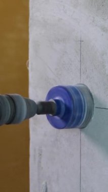 Bir elektrikçi elmas çekirdekli prizler için delik açar. Yakın plan.