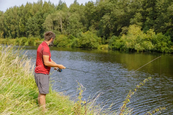 Un hombre con barba está pescando en el río. —  Fotos de Stock