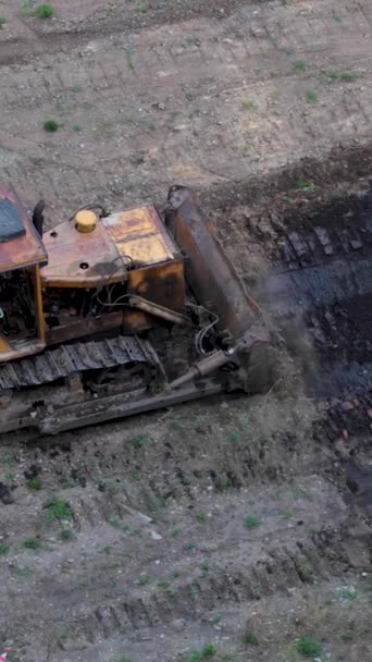 A traktor összegyűjti a földet egy nagy halom egy vödör. Kilátás felülről — Stock videók