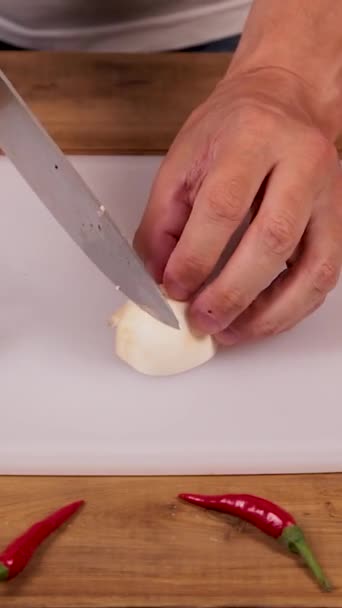 Un homme coupe des champignons sur une planche à découper pour faire une julienne. — Video