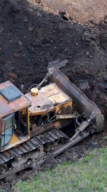 Traktör, dünyayı bir kovayla birlikte büyük bir yığın halinde topluyor. Yukarıdan görüntüle