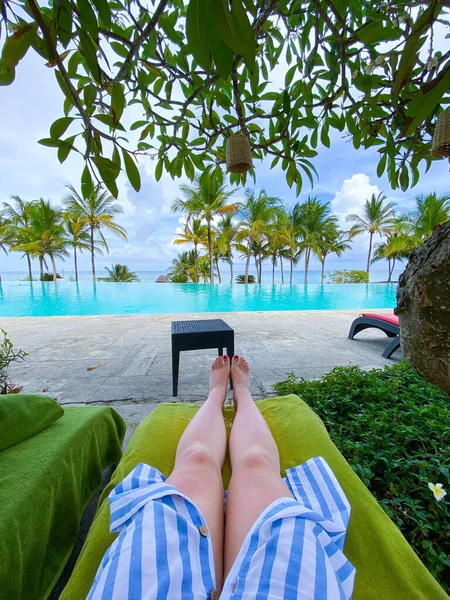 Piernas femeninas, vista de la piscina infinita y el océano en Kiwengwa, Zanzíbar — Foto de Stock