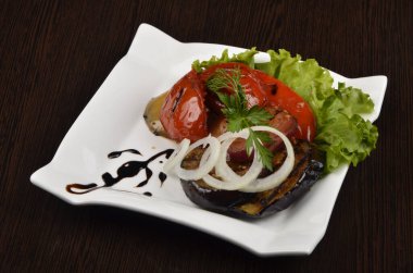 biberli fırında patlıcan ve taze doğranmış soğanlı marul yaprağının üzerinde et.