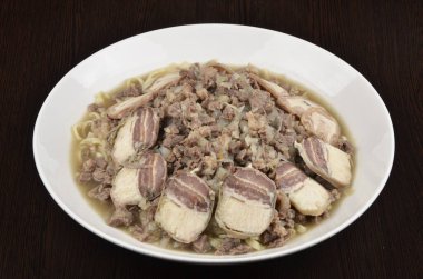 Erişte, et ve soğanlı domuz pastırması.