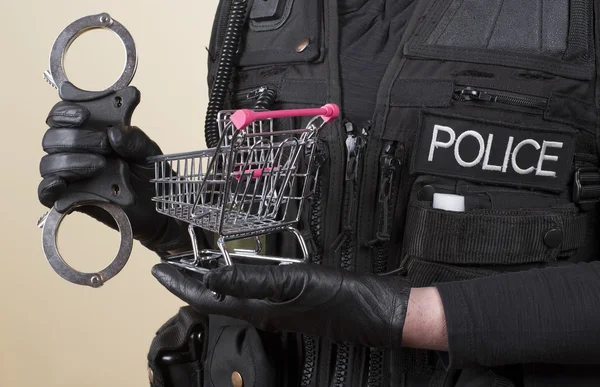 Ladendiebstahl-Konzept Einkaufswagen und Polizei-Handschellen — Stockfoto
