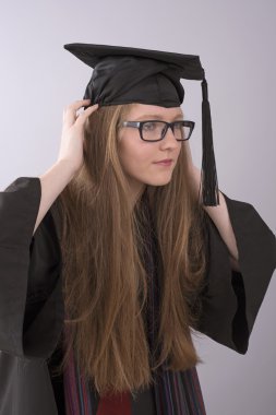 Bir kap ve elbise giymiş mezunu