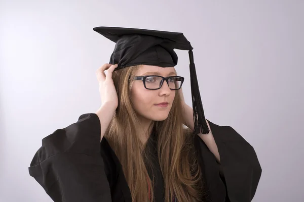 Examen på sig en mössa och klänning — Stockfoto