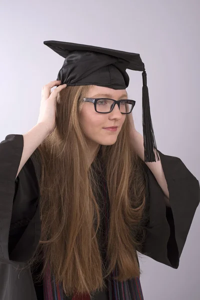 Absolvent trägt Mütze und Kleid — Stockfoto