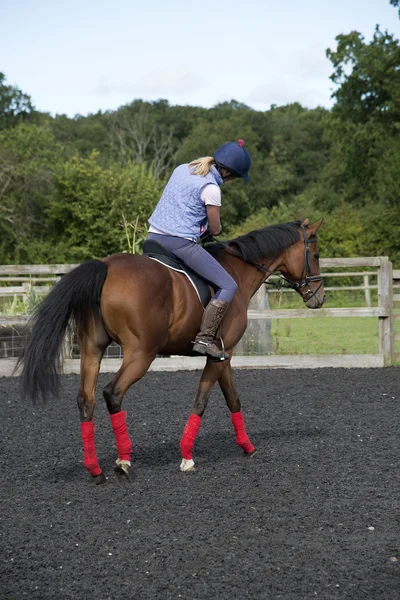 Mulher montando seu cavalo em uma paddock — Fotografia de Stock