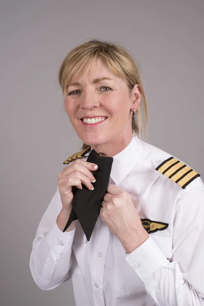Female airline pilot adjusting her uniform cravat — Stock Photo, Image