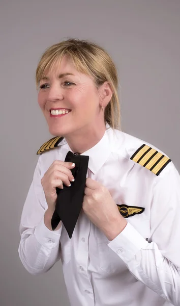 Pilote de ligne féminine ajustant sa cravate uniforme — Photo