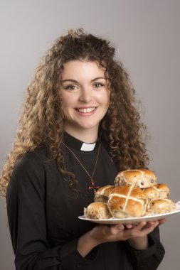 Bir tabak sıcak Cross buns Paskalya zamanı ile genç çekici papaz