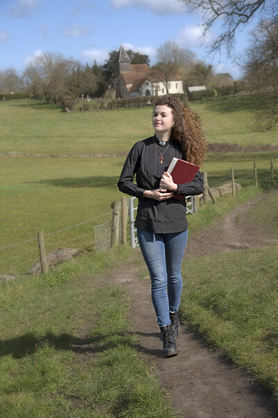 Attractive young vicar walking in her parish