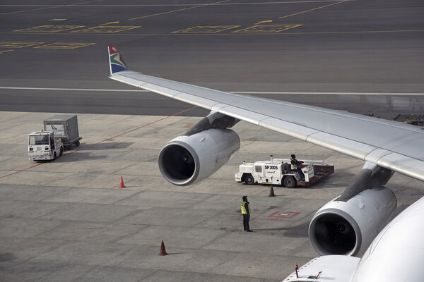 Сотрудники аэропорта обслуживают самолет в Международном аэропорту Кейптаун ЮАР
