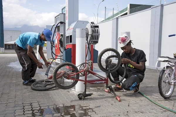 Junge Männer flicken eine Reifenpanne am Rad seines Fahrrads — Stockfoto