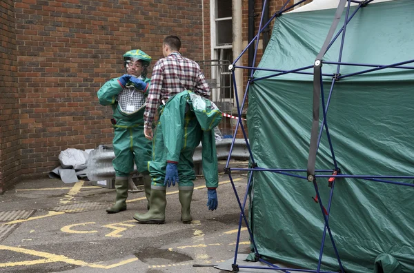 Tenda de descontaminação e trabalhadores vestindo roupas protetoras — Fotografia de Stock